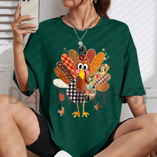 Front view of the Thanksgiving Patchwork Turkey Shirt for Women displaying mixed print turkey and maple leaf artwork across the chest of a soft casual graphic tee. - dogmomhat