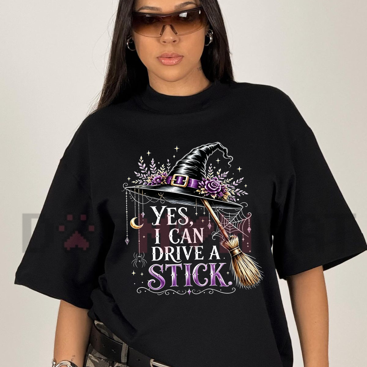 Front view of the Women's "Yes I Can Drive A Stick" T-Shirt showing the funny witch hat and broom graphic printed across the chest - dogmomhat