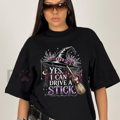 Front view of the Women's "Yes I Can Drive A Stick" T-Shirt showing the funny witch hat and broom graphic printed across the chest - dogmomhat