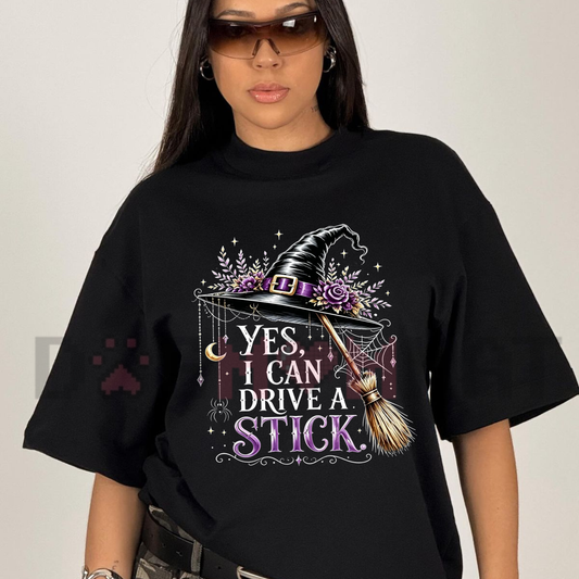 Front view of the Women's "Yes I Can Drive A Stick" T-Shirt showing the funny witch hat and broom graphic printed across the chest - dogmomhat
