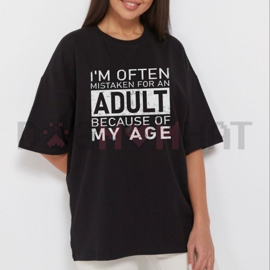 Front view of the black "I'm Often Mistaken For An Adult Because Of My Age" T-Shirt showing the clean, bold typographic joke design on the chest - dogmomhat