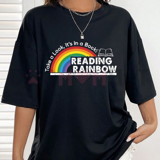 Front view of the white Retro Reading Rainbow Graphic Tee showing the vibrant vintage shooting star logo and book lover slogan across the chest - dogmomhat